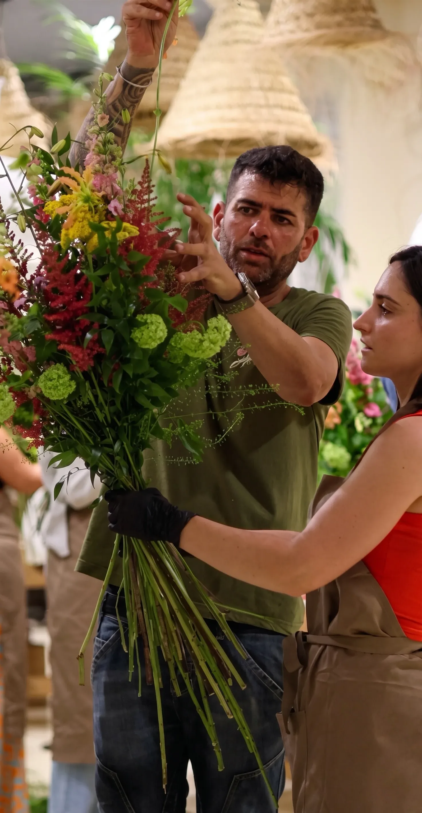 Maestra florista componiendo un ramo con flor fresca en el aula